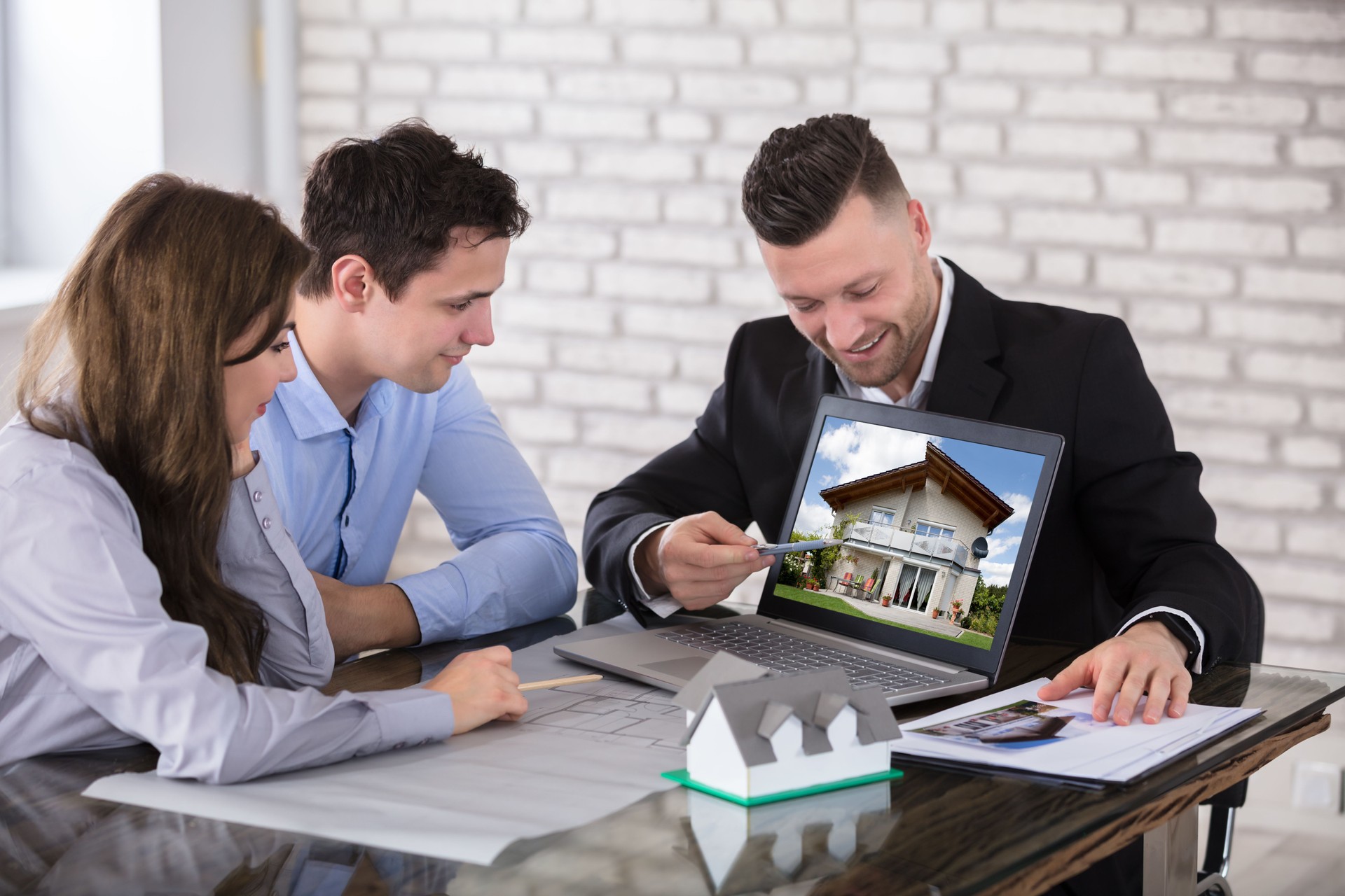 Architect Showing House Model To Couple In Office